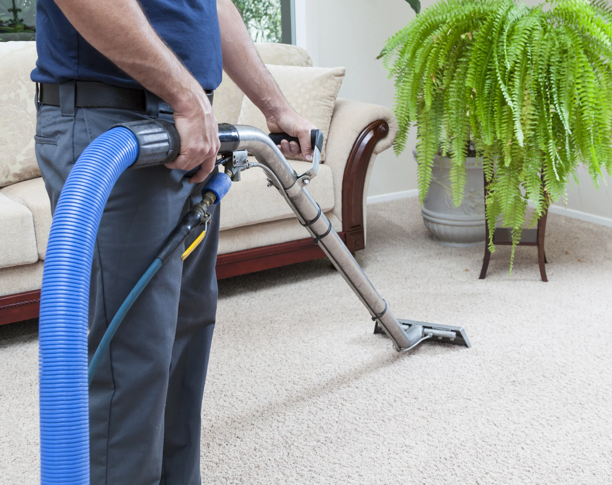 Professional carpet cleaning service Sedona AZ – technician using steam extraction machine on living room carpet